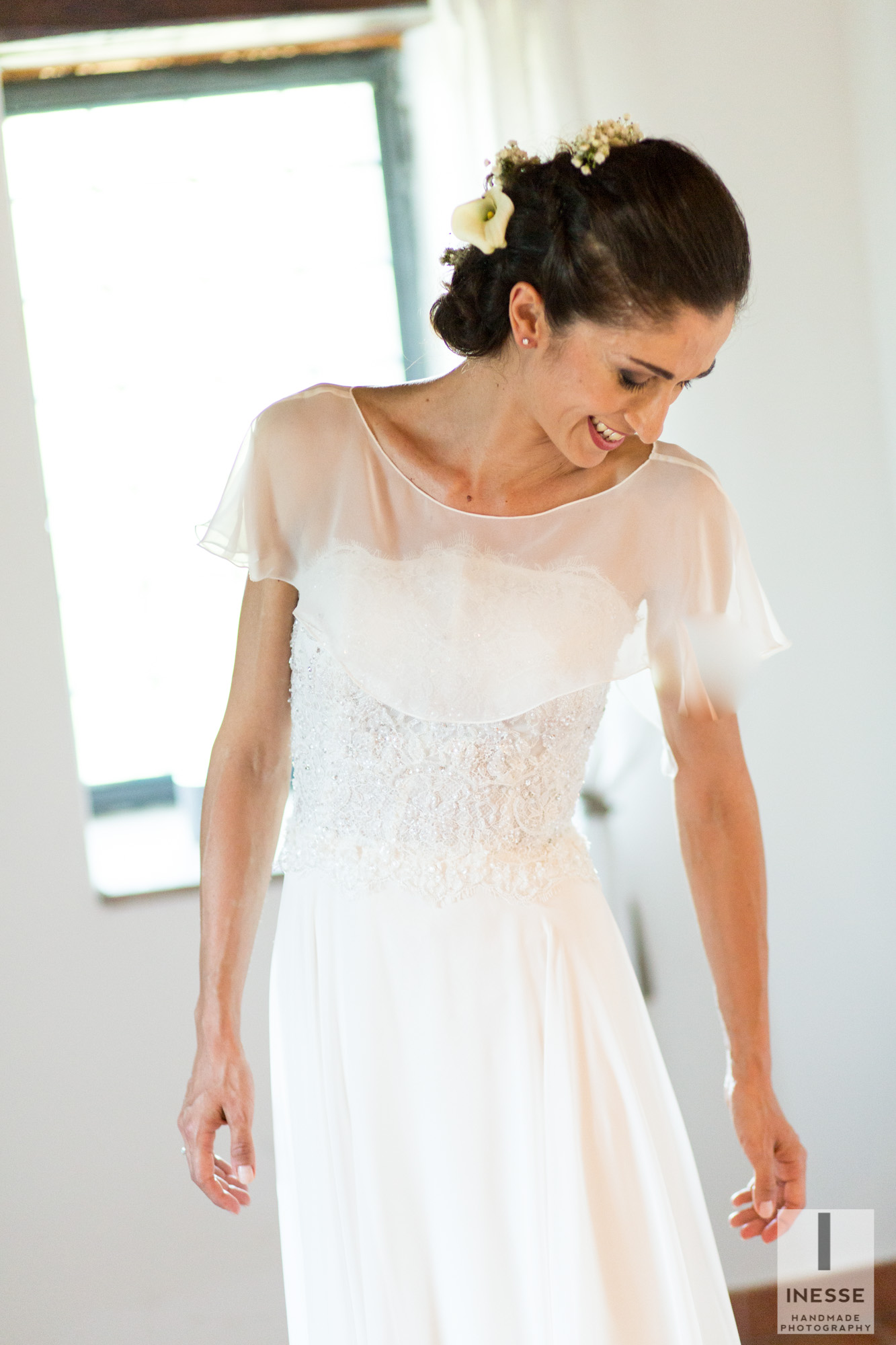 La sposa sorride e guarda il vestito indossato